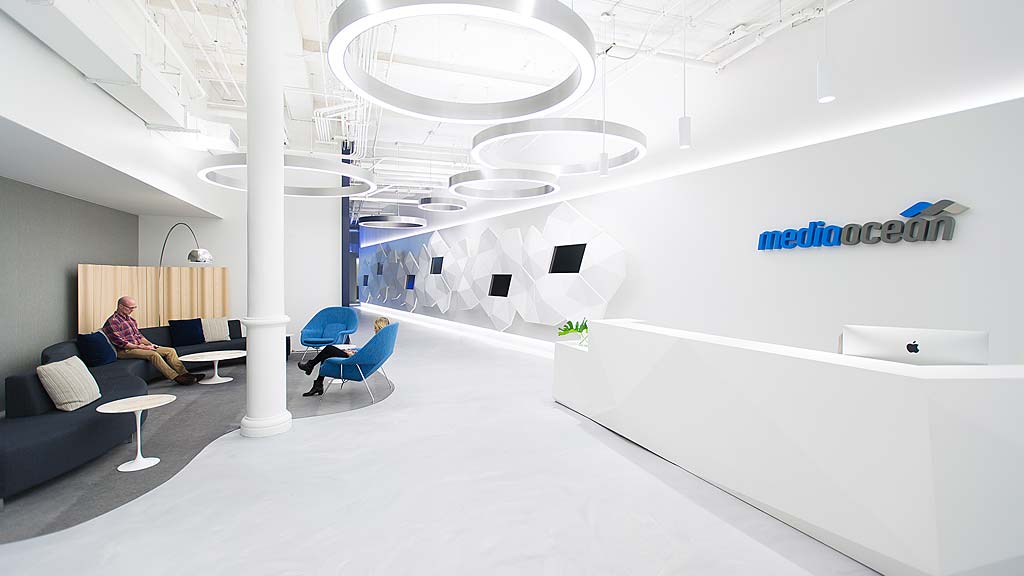 A person sitting on a couch in a room with white walls.