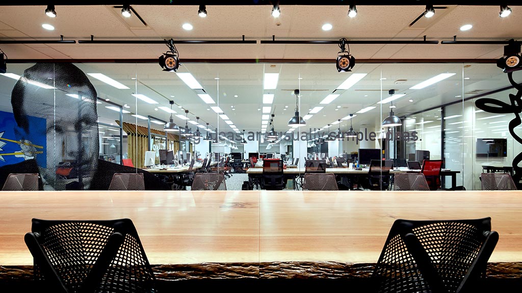A large room with a large round table and chairs.