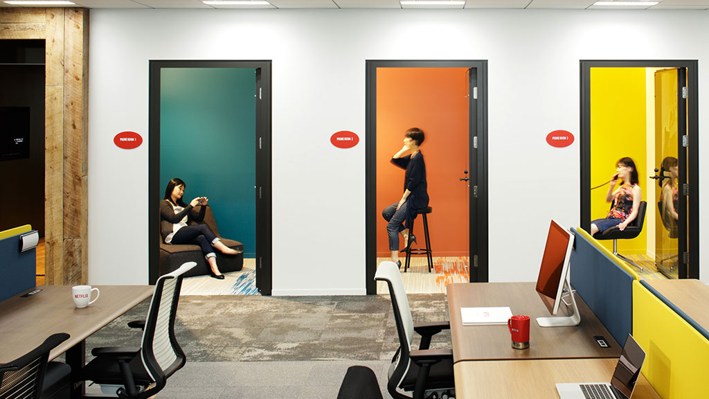 A woman taking a picture of a man playing frisbee.