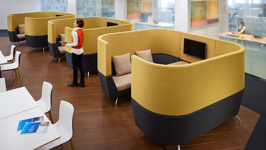 A person standing in a room with chairs and tables.