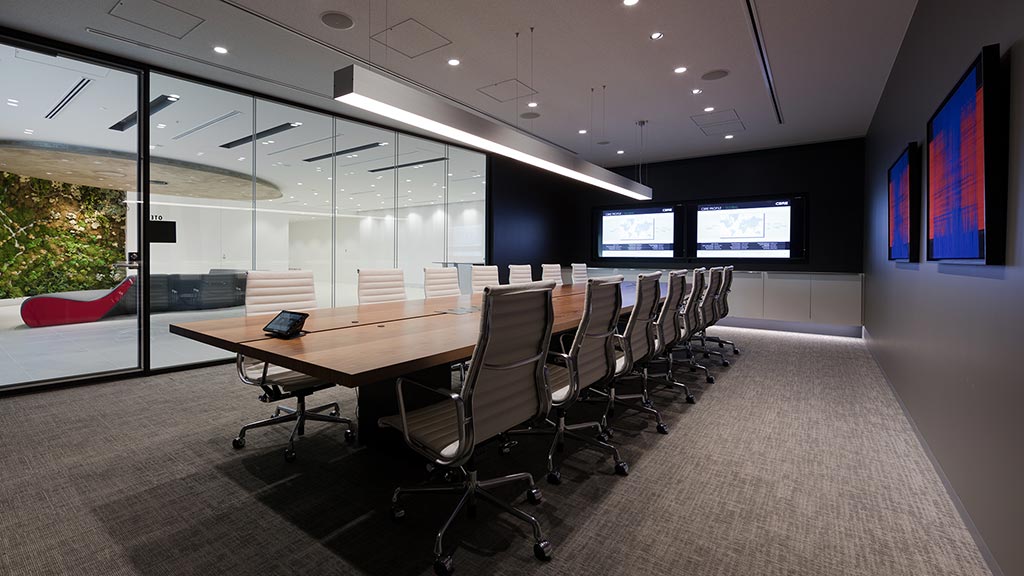 A conference room with a large table and chairs.