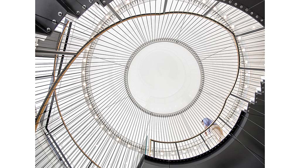 A spiral staircase with people.