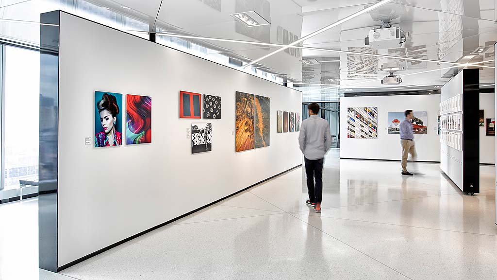 A man and a woman looking at art on the wall.