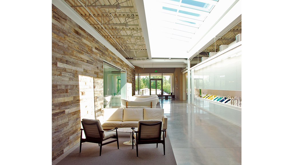 A room with a couch and chairs.