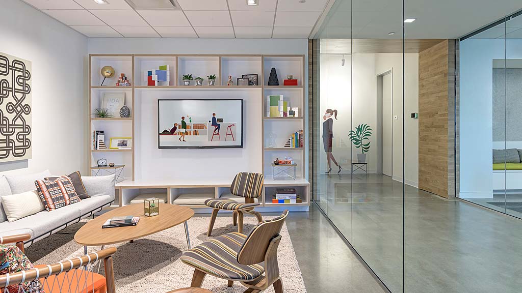 A room with a glass wall and a table and chairs.