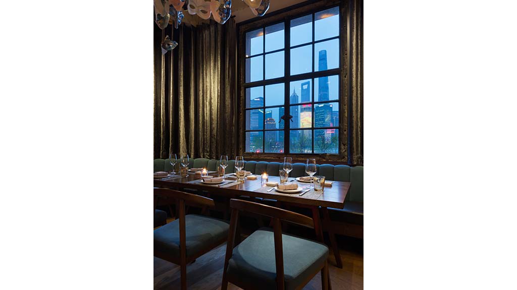 A table with plates and glasses on it in front of a window.