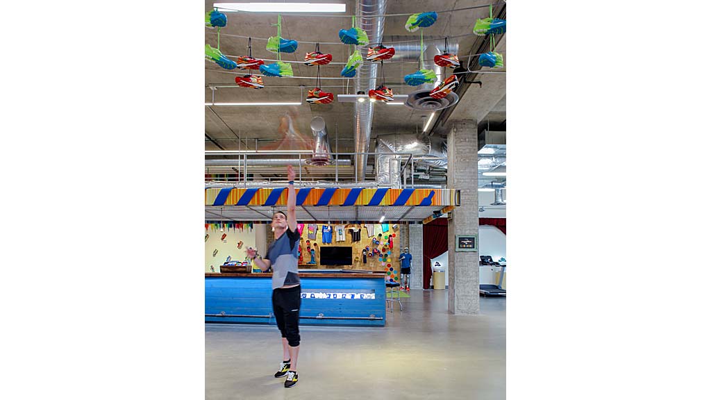 A person standing in a room with a table and clothes.