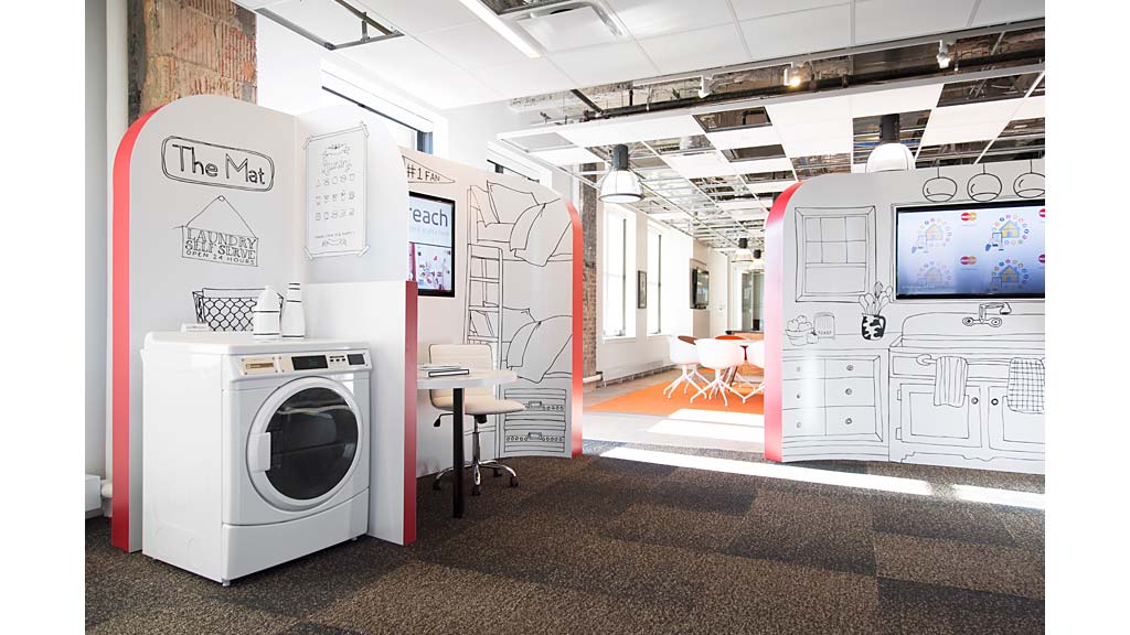 A room with a washing machine and a table.