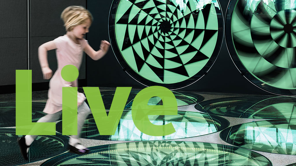 A girl standing next to a large glass display.