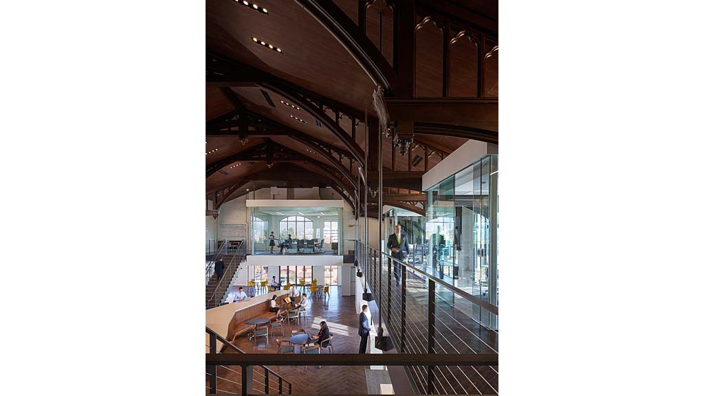 A large room with glass walls and people walking around.