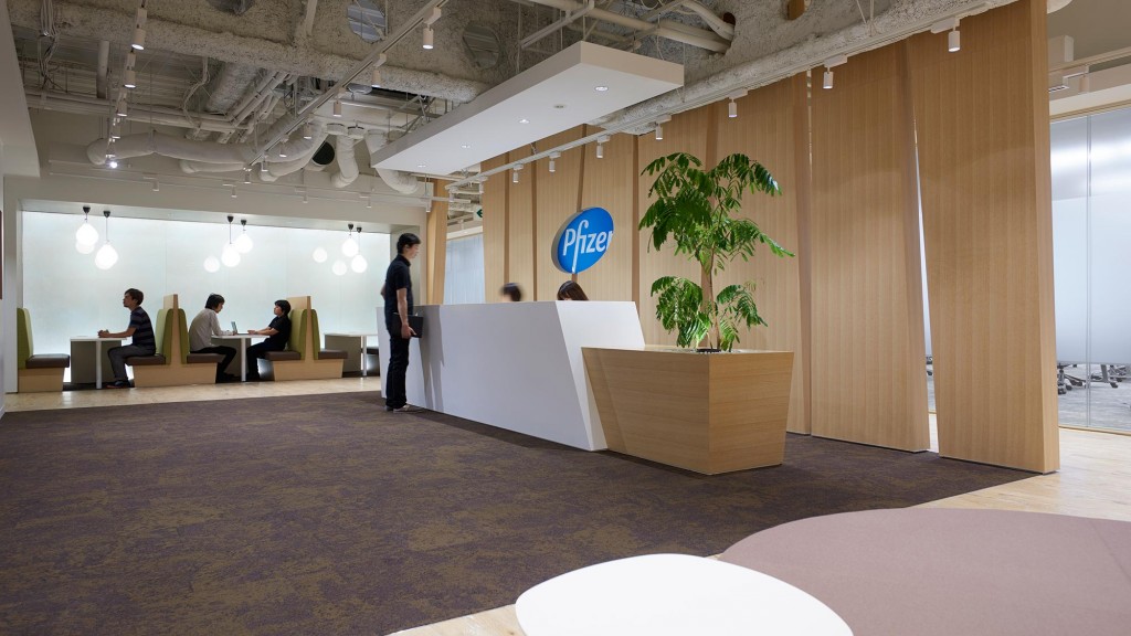 A person standing in a room with people sitting at desks.