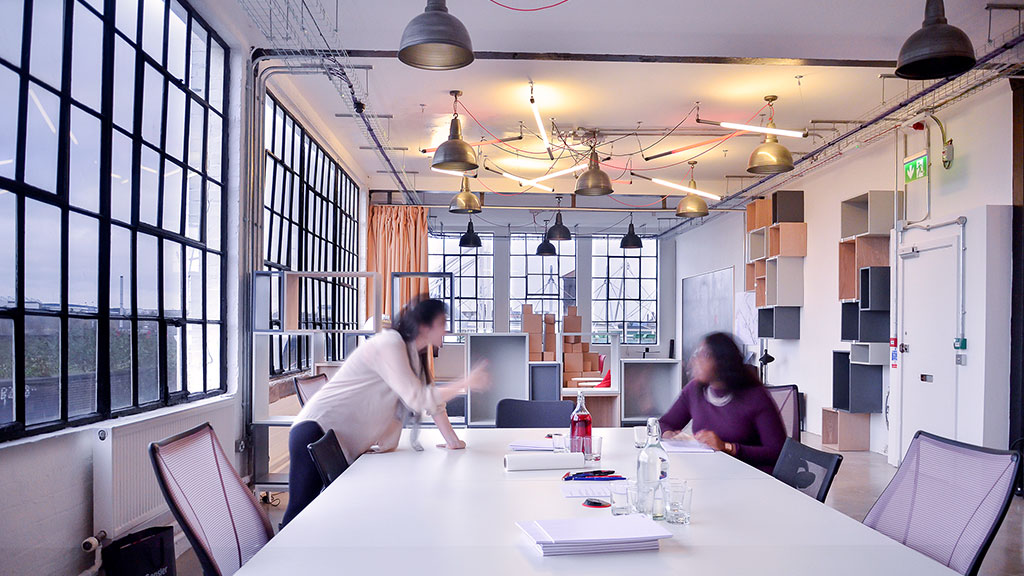 A couple of people sitting at a table with a large window.
