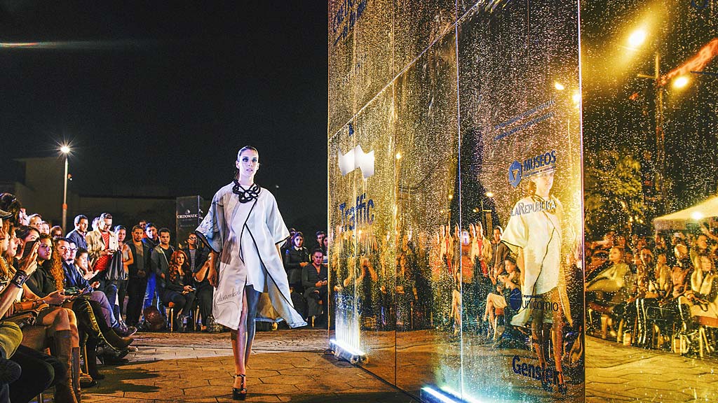 A man walking down a stage with a crowd watching.