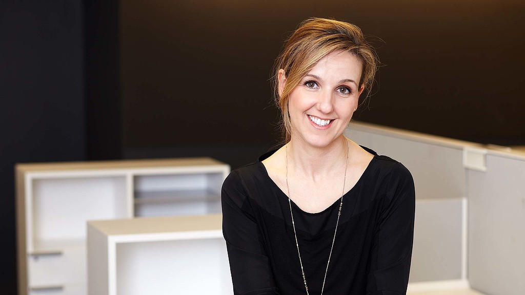 A person smiling in front of a computer.