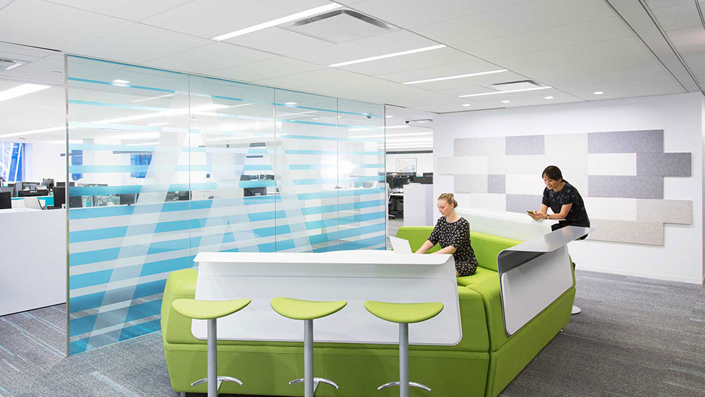 A couple of people sitting at a table in a room with a large glass wall.