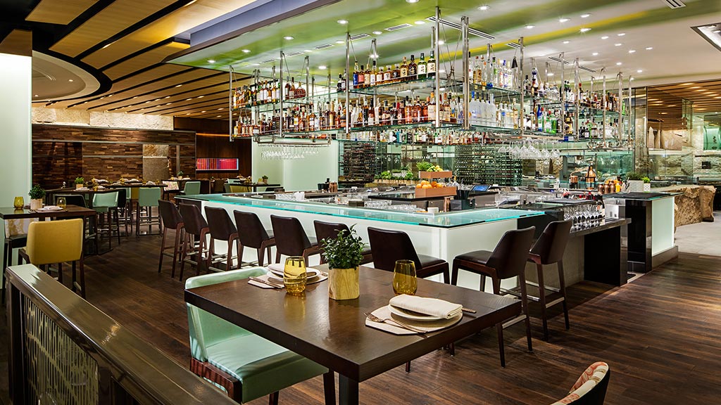 A restaurant with a large bar and tables.