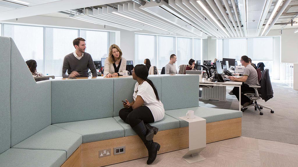 A group of people sitting at a table in an office.