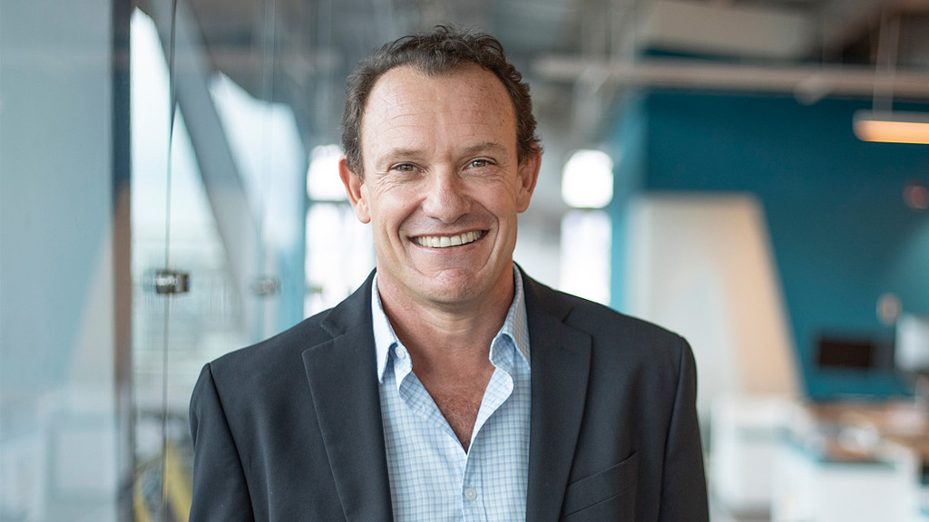 A man in a suit smiling.