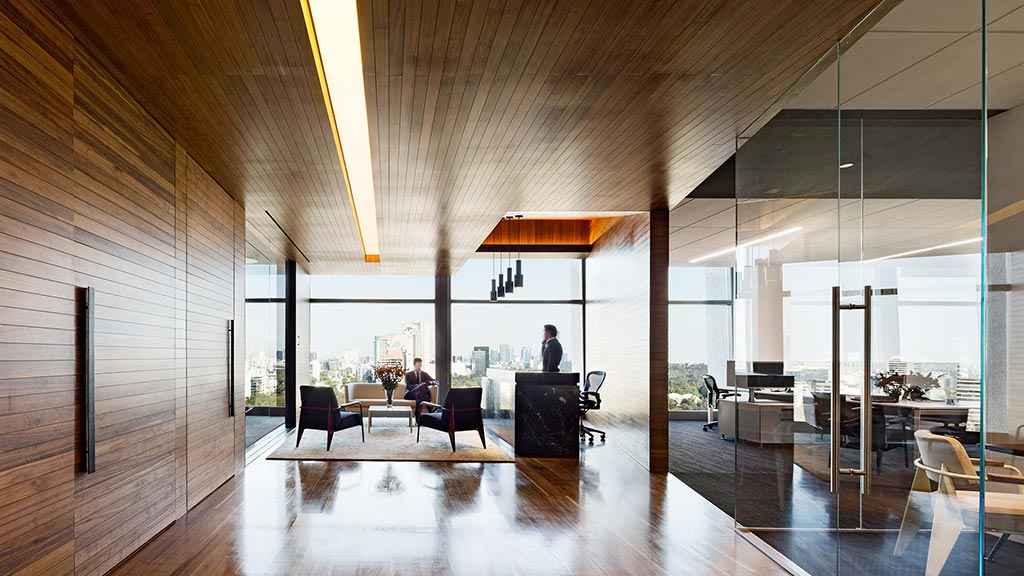 A room with a large glass wall and a large wood floor.