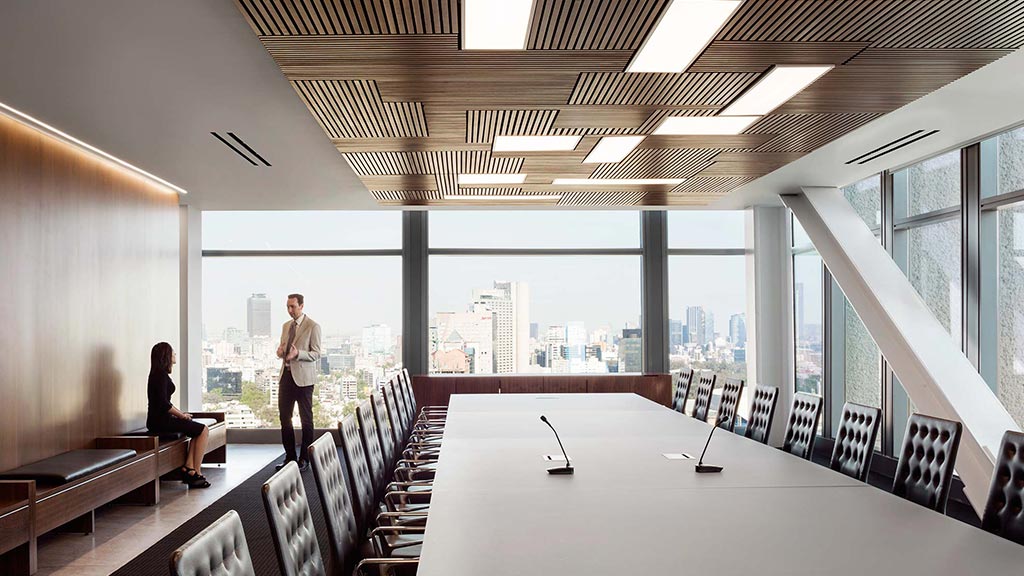 A man and woman standing in a room with a large window.
