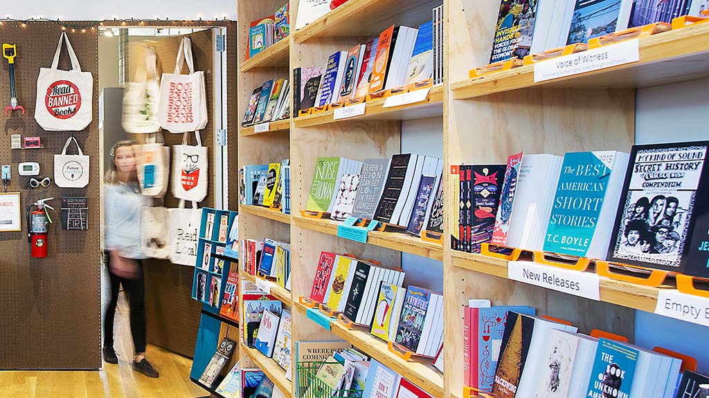 A person standing in front of a shelf of books.