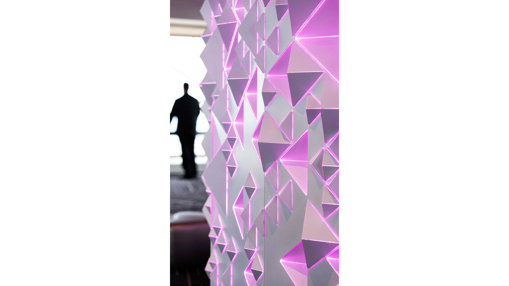 A person standing in a room with a large group of purple squares.