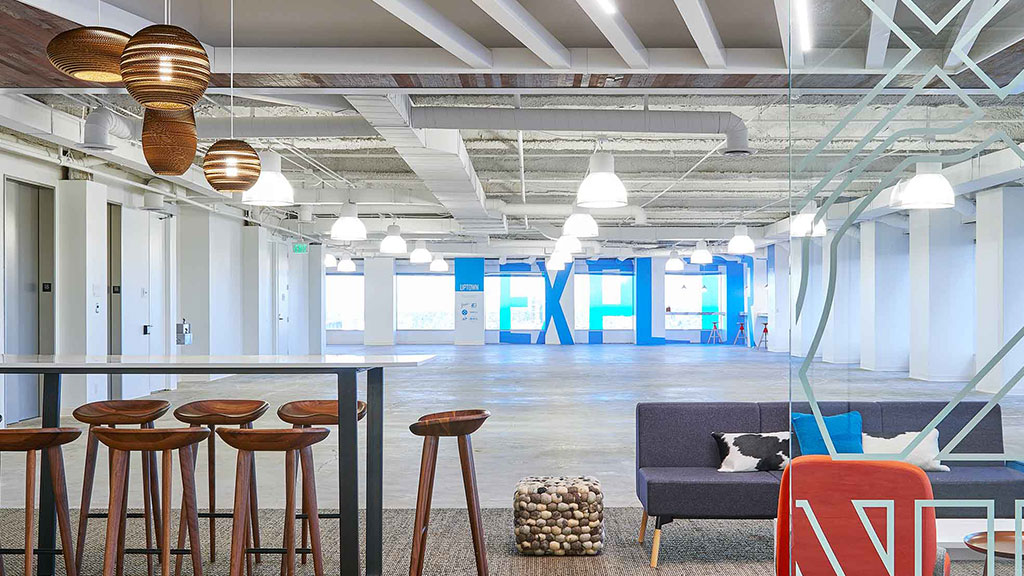 A room with a couch and chairs.