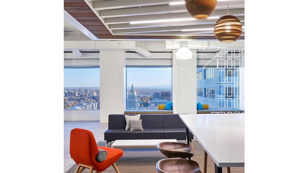 A room with a couch and chairs.