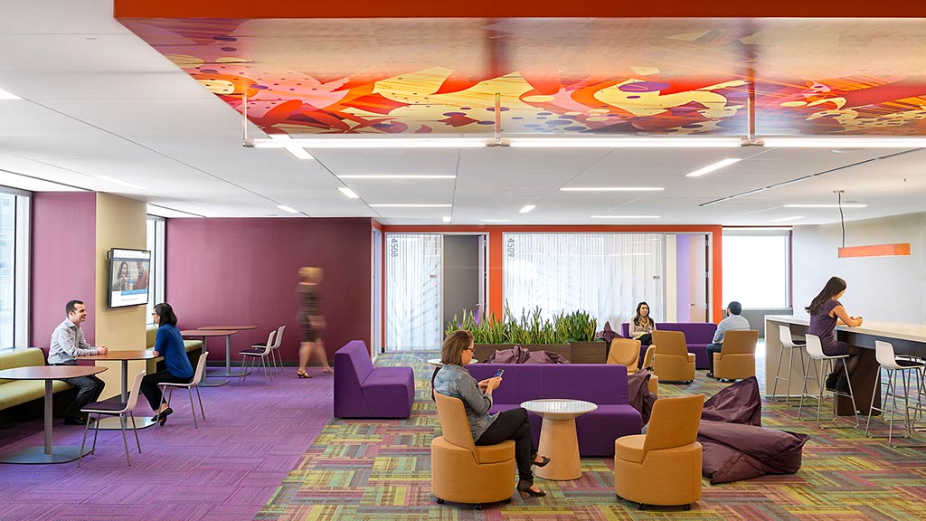 A group of people sitting in a room with colorful furniture.