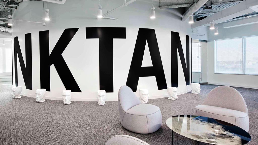 A room with a couch and chairs.