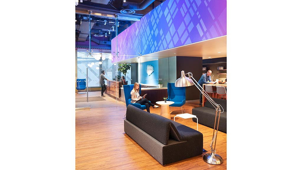 A person sitting in a chair in a room with a purple wall.