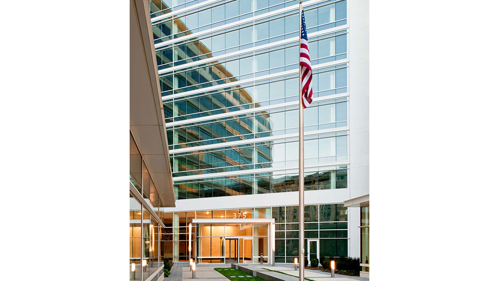 A flag on a pole in front of a building.