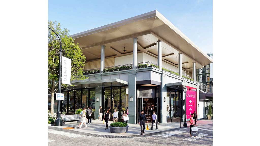 A building with columns and people walking around.