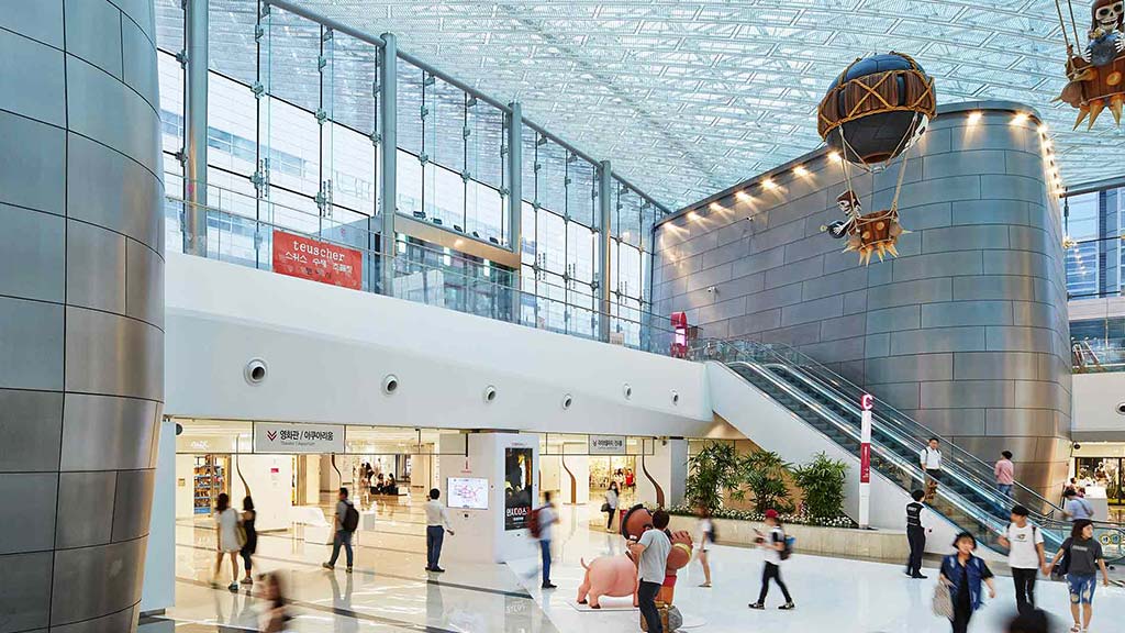 A large glass building with people walking around.