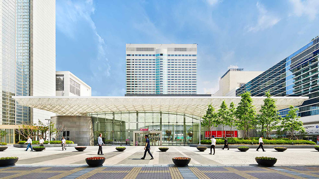 A courtyard with people and buildings in the background.