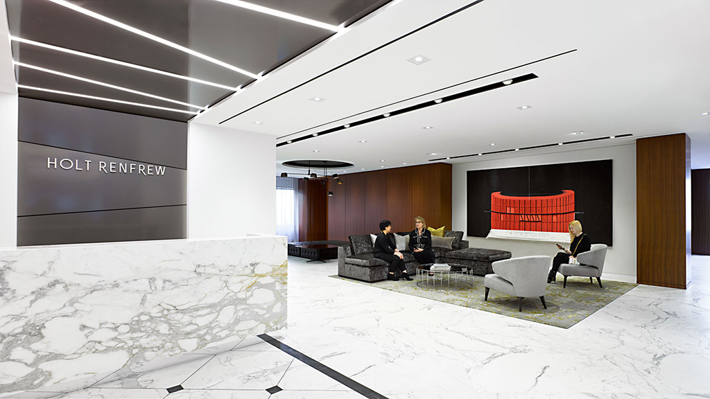 A group of people sitting in a room with a large screen.