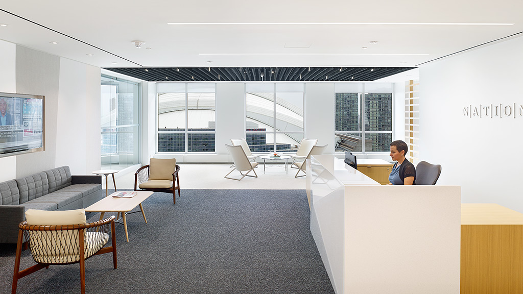 A person sitting at a table in a room with a large window.