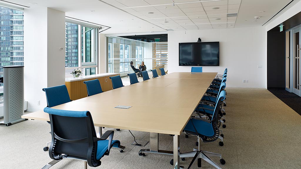 A conference room with a large table and chairs.