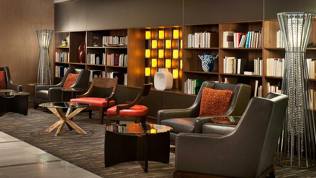 A room with a table chairs and a bookcase.