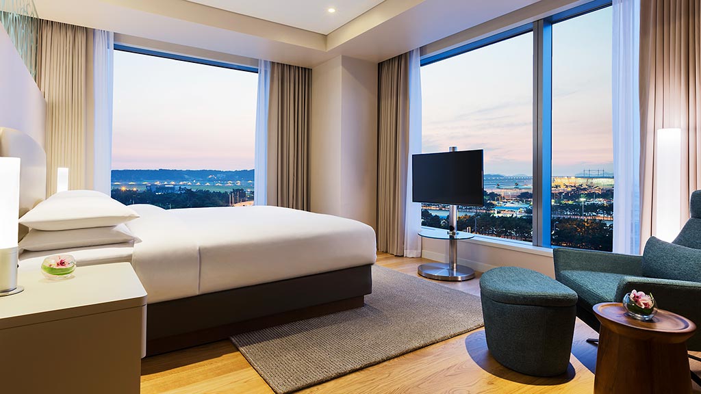 A bedroom with a large window.