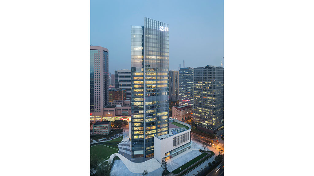 A tall glass building in a city.