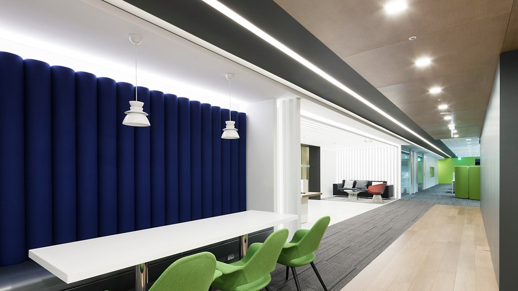 A room with a blue wall and green chairs.