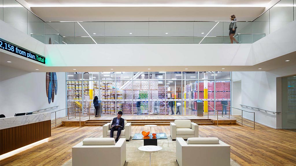 A person sitting on a bench in a large room with a large display of art.