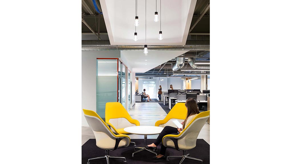 A group of people sitting in a room with tables and chairs.