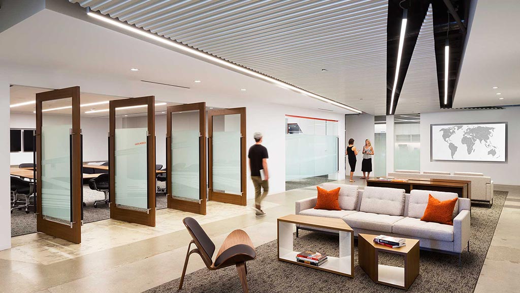 A room with a couch and a table and chairs.