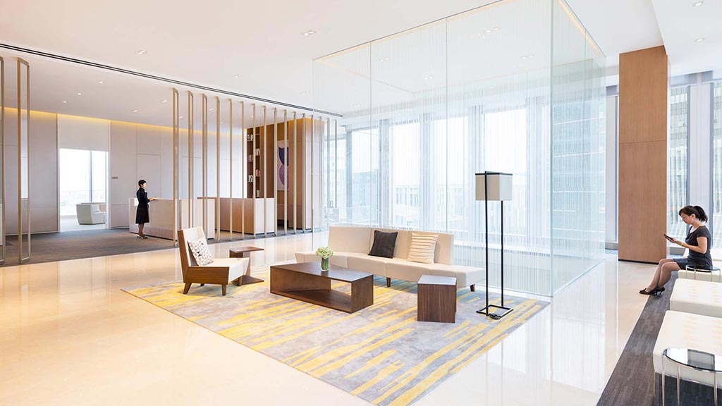 A room with a couch and a table with chairs and a person standing in the background.