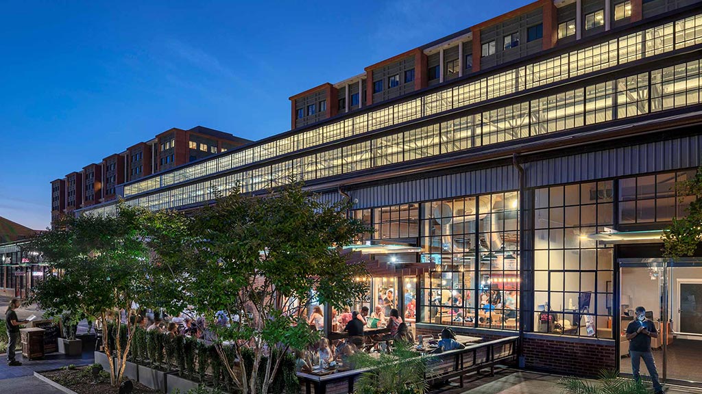A building with glass windows and people outside.