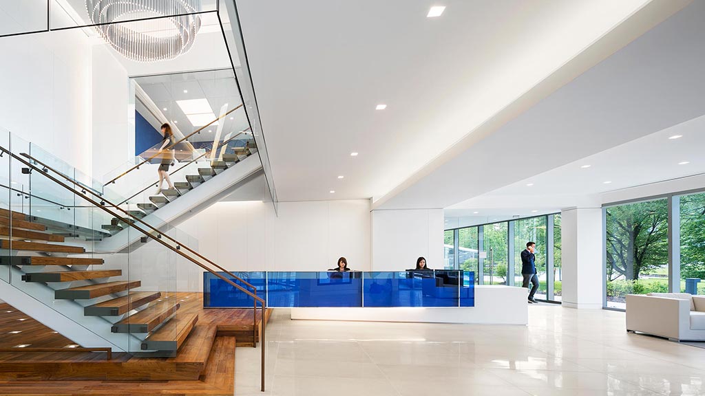 A large room with a staircase and a few people.