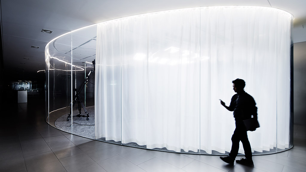 A man standing in front of a large white curtain.