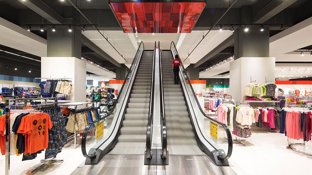 A person walking down a flight of stairs in a clothing store.